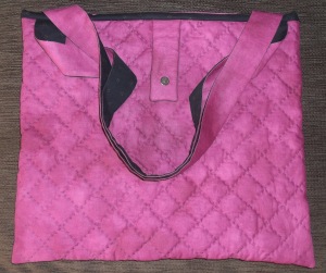 A simple, but effective hand quilted diamond pattern over the entirety of the raspberry coloured fabric and to finish off , a magnetic clasp topped with a chunky black button! 
